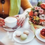 Cup of coffee and bouquet of flowers on the table